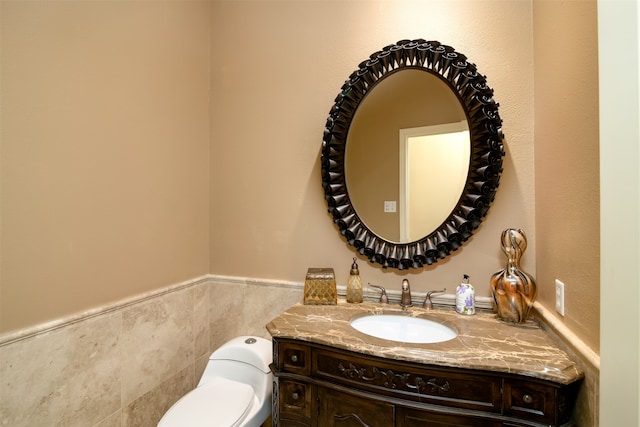 bathroom featuring tile walls, vanity, and toilet