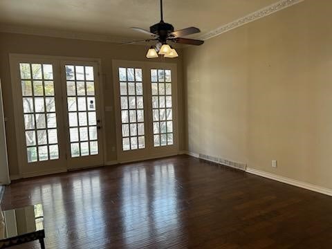 empty room featuring ceiling fan, ornamental molding, and dark wood-type flooring