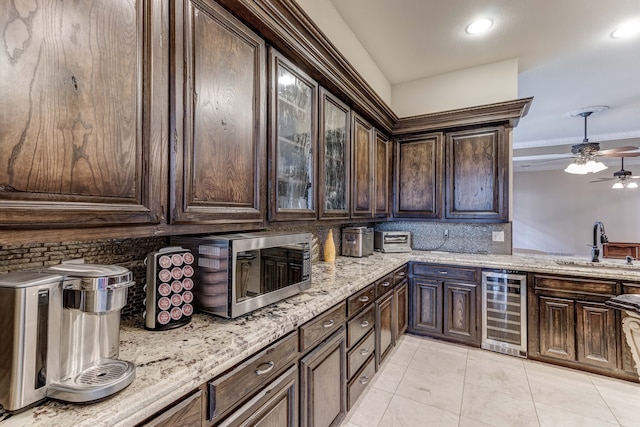 kitchen featuring wine cooler, dark brown cabinetry, and tasteful backsplash