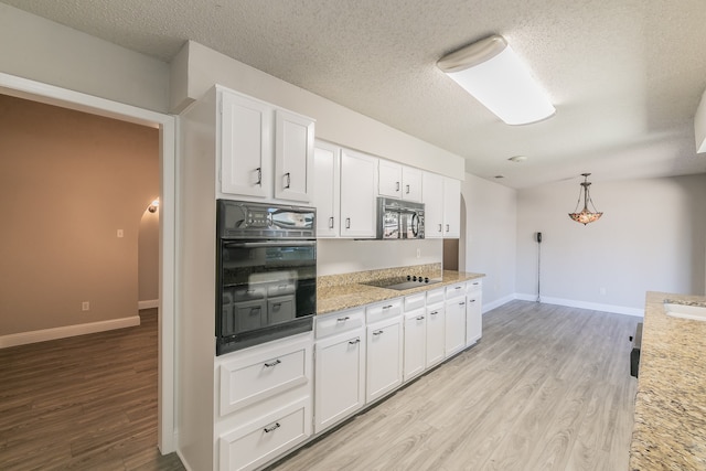 kitchen featuring black appliances, white cabinetry, light hardwood / wood-style flooring, and a textured ceiling