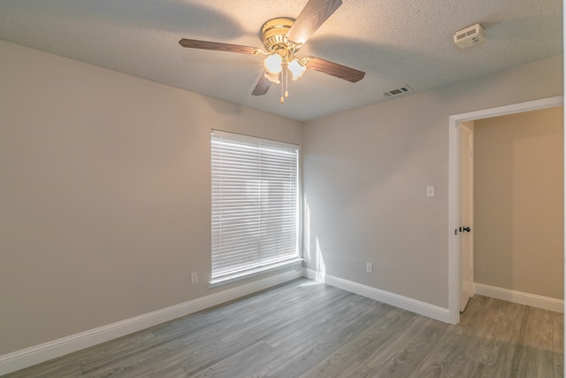 spare room with a textured ceiling, ceiling fan, and hardwood / wood-style flooring