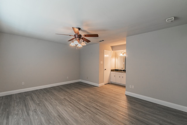 unfurnished bedroom with ceiling fan, hardwood / wood-style flooring, and connected bathroom