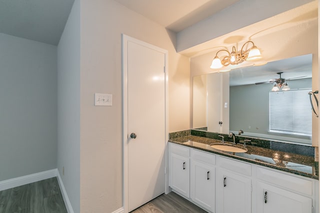 bathroom with ceiling fan with notable chandelier, wood-type flooring, and vanity