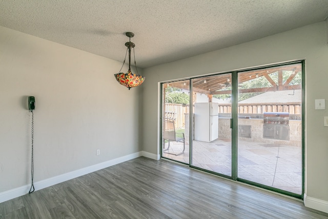 empty room featuring hardwood / wood-style flooring and a textured ceiling