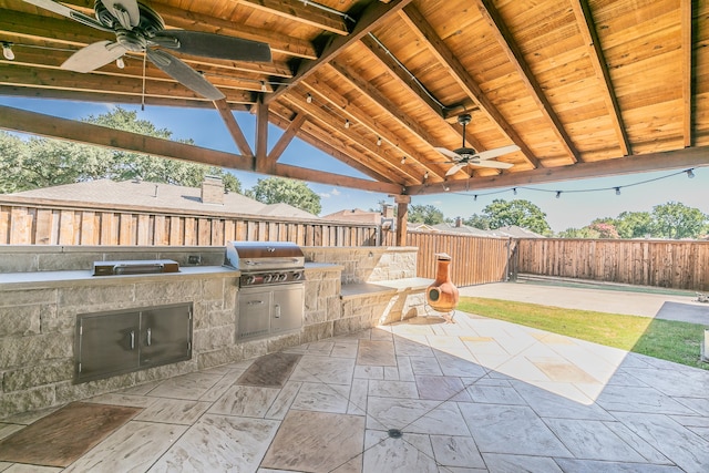 view of patio featuring exterior kitchen, ceiling fan, a gazebo, and grilling area