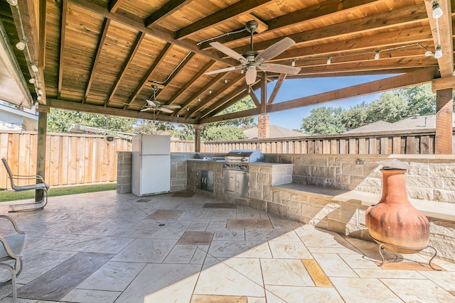 view of patio featuring exterior kitchen, area for grilling, and ceiling fan