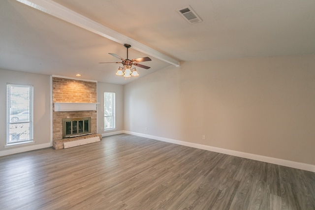 unfurnished living room featuring ceiling fan, dark hardwood / wood-style floors, lofted ceiling with beams, and a fireplace