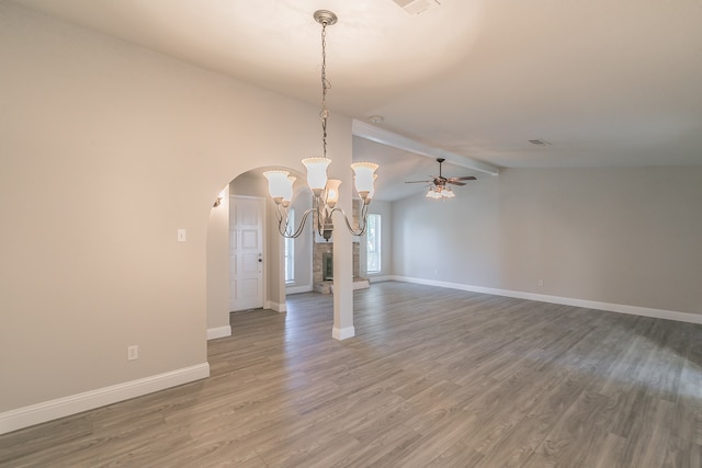 unfurnished dining area featuring ceiling fan with notable chandelier, wood-type flooring, and vaulted ceiling with beams