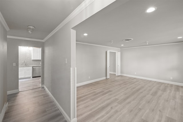 interior space with light wood-type flooring, ornamental molding, and sink