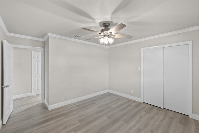 unfurnished bedroom with crown molding, ceiling fan, a closet, and light wood-type flooring