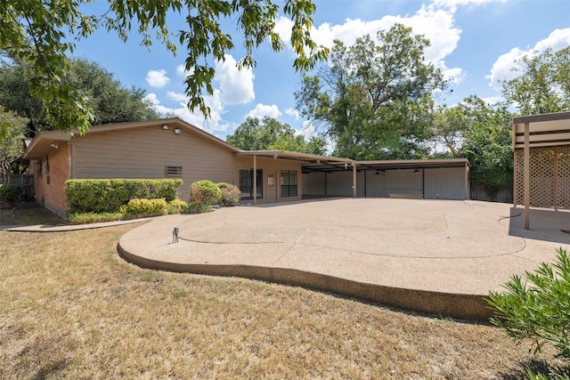 back of house with a lawn and a patio