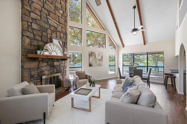 living room with hardwood / wood-style floors, high vaulted ceiling, a fireplace, beamed ceiling, and ceiling fan