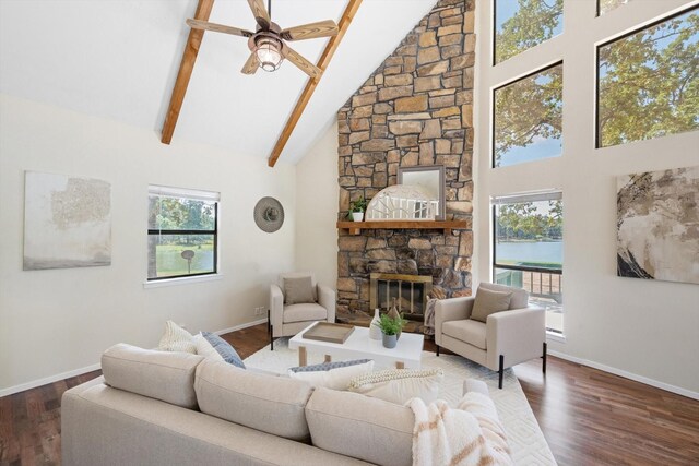 living room featuring dark wood-type flooring, ceiling fan, beam ceiling, high vaulted ceiling, and a fireplace