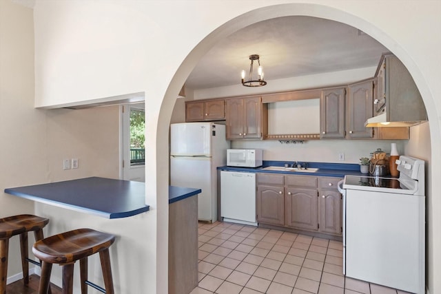 kitchen with light tile patterned flooring, white appliances, and sink