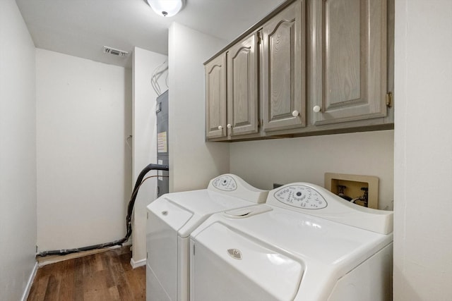 clothes washing area featuring visible vents, baseboards, separate washer and dryer, cabinet space, and dark wood-style flooring