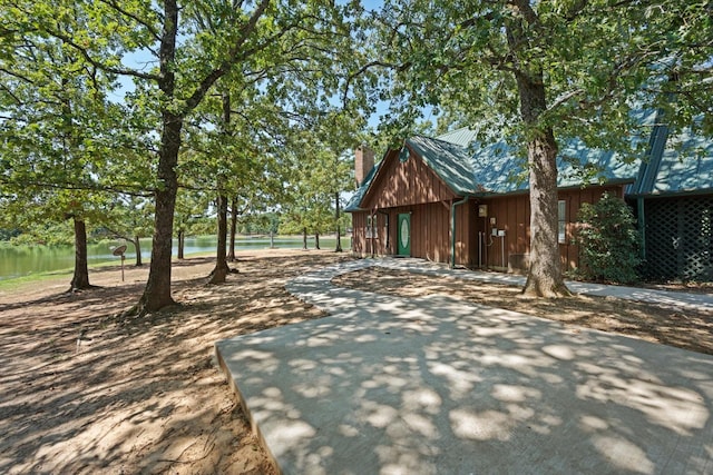 view of front of house featuring a chimney and a water view