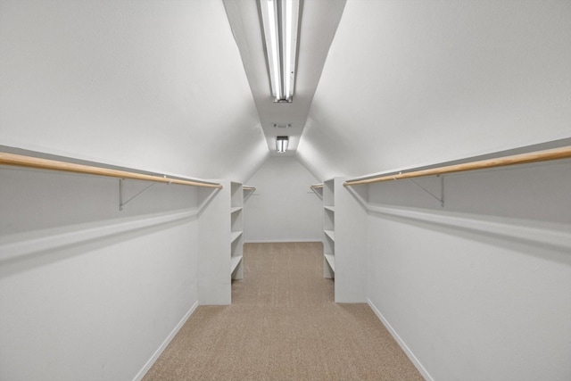 spacious closet featuring lofted ceiling and carpet flooring