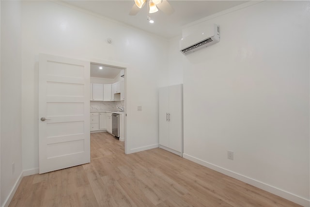 interior space featuring a wall mounted AC, ceiling fan, ornamental molding, and light wood-type flooring