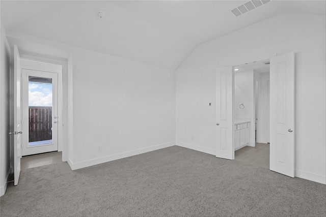 unfurnished bedroom with light carpet and vaulted ceiling