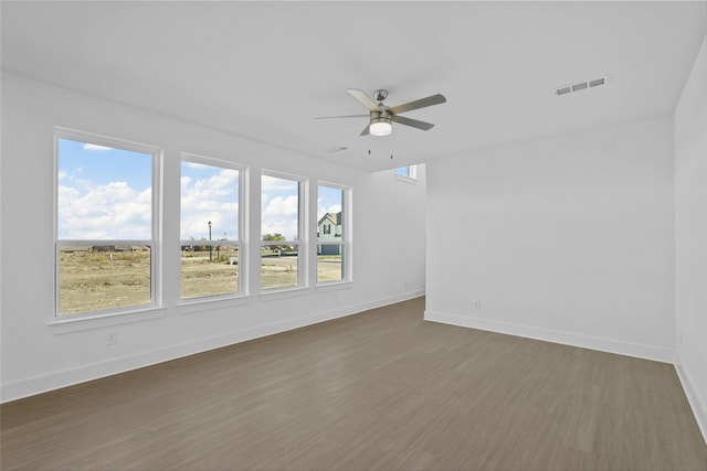 unfurnished room with ceiling fan and dark wood-type flooring