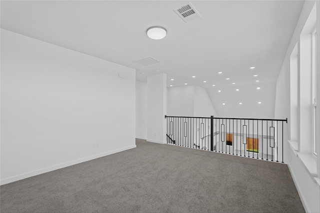 carpeted spare room featuring lofted ceiling