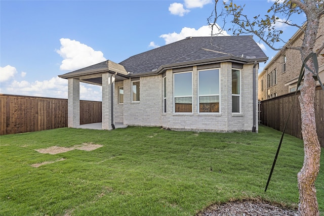 rear view of house featuring a yard