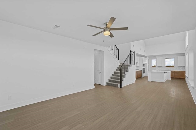 unfurnished living room featuring hardwood / wood-style floors and ceiling fan