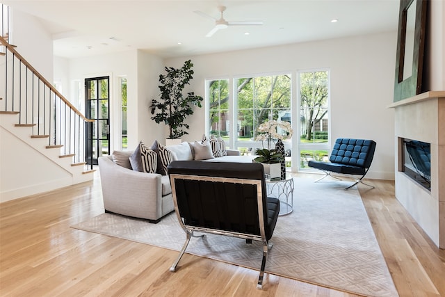 living room featuring light hardwood / wood-style flooring and ceiling fan