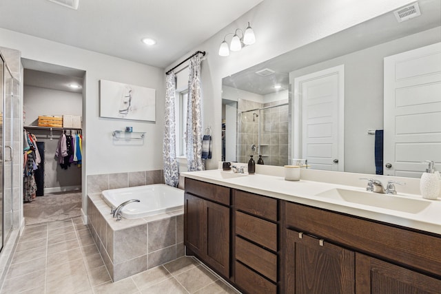 bathroom with tile patterned floors, independent shower and bath, and vanity