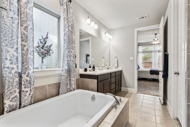 bathroom with vanity, tiled tub, tile patterned floors, and ceiling fan