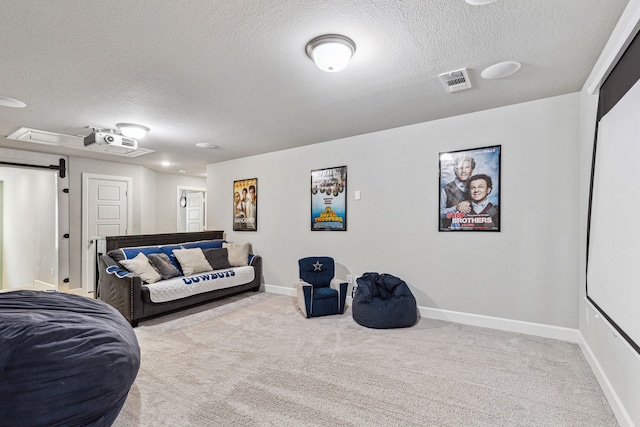 living room with a textured ceiling, a barn door, and light carpet