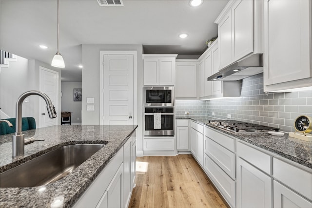 kitchen with light hardwood / wood-style flooring, sink, appliances with stainless steel finishes, and white cabinetry