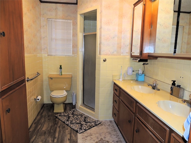 bathroom featuring tile walls, vanity, toilet, and a shower with shower door