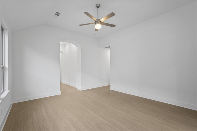 spare room with ceiling fan, light wood-type flooring, and vaulted ceiling