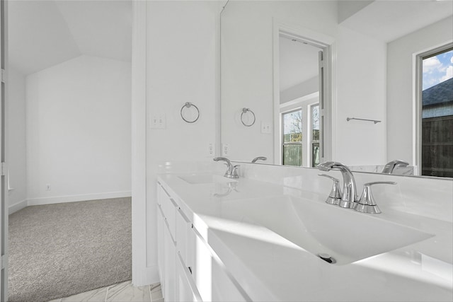 bathroom with vanity, lofted ceiling, and a healthy amount of sunlight