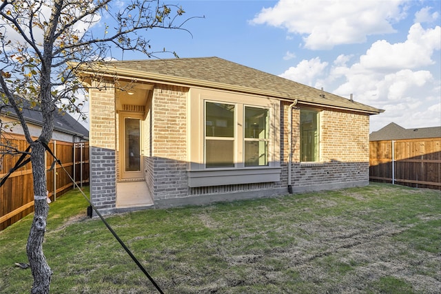 rear view of property with a lawn