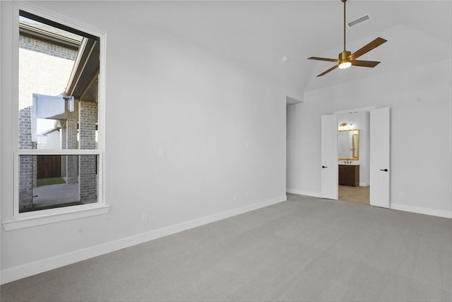 unfurnished room with light colored carpet, high vaulted ceiling, and ceiling fan