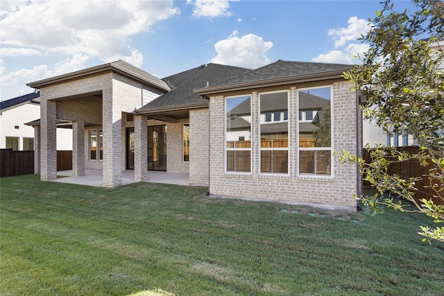 rear view of property featuring a patio area and a yard