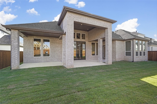 rear view of property with a yard and a patio