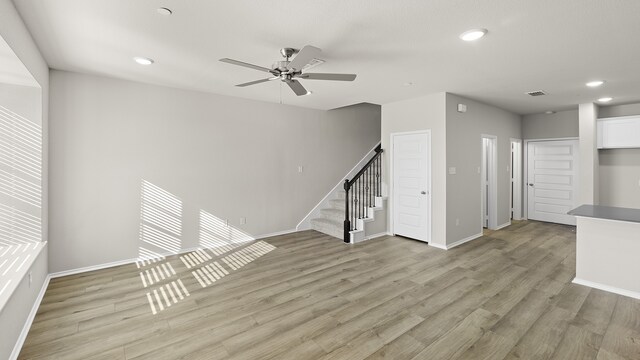 unfurnished living room with ceiling fan and light wood-type flooring