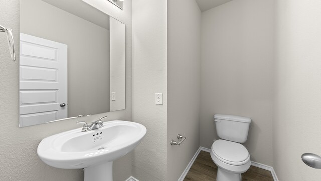 bathroom featuring hardwood / wood-style flooring, toilet, and sink