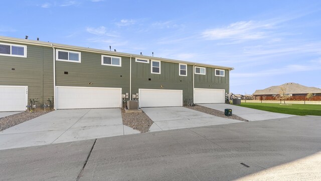 back of house with cooling unit and a garage