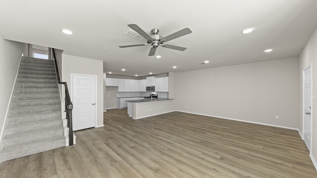 unfurnished living room with ceiling fan and light wood-type flooring