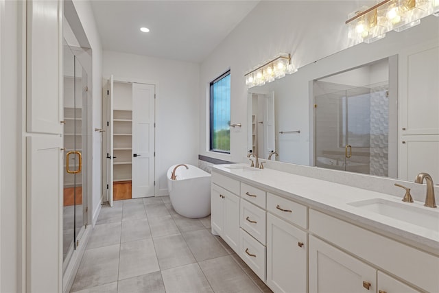 full bathroom featuring tile patterned floors, a sink, a shower stall, and double vanity