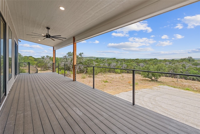 wooden terrace featuring ceiling fan and a wooded view