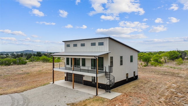 view of front of property with metal roof, driveway, a mountain view, and a garage