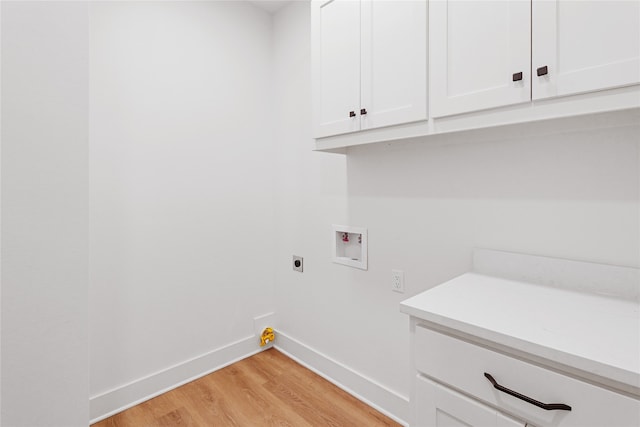 washroom featuring washer hookup, light wood finished floors, cabinet space, hookup for an electric dryer, and baseboards