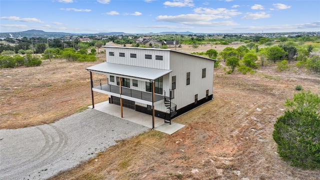 view of front facade with driveway, a mountain view, and metal roof