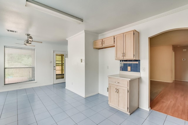 kitchen featuring light tile patterned floors, tasteful backsplash, ornamental molding, light brown cabinets, and ceiling fan