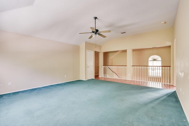 carpeted spare room featuring lofted ceiling, ceiling fan, and a textured ceiling